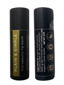 Two tubes of Ancient Tallow Therapeutic Lip Balm, one standing upright and the other lying down. The standing tube has a black and gold label, while the lying tube has a mostly black label with some text symbols.