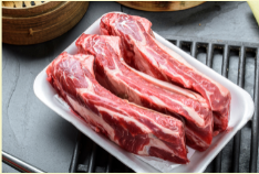 A set of raw beef rib bones on a white plate, presumably the product referred to as 'BioComplete Beef Rib Large'.