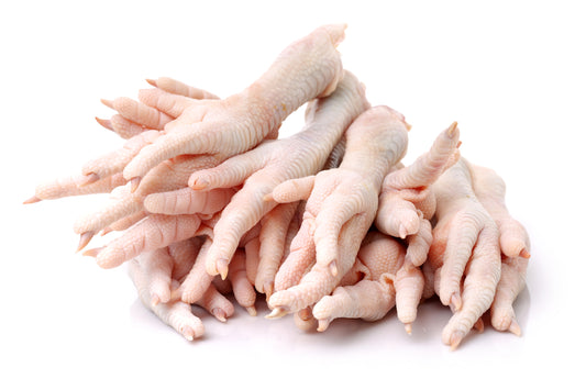 A pile of raw, frozen chicken feet on a white background.
