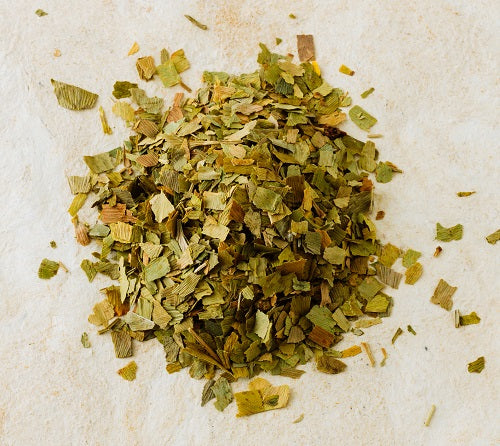 A pile of dried, chopped Ginkgo biloba leaves on a light background.