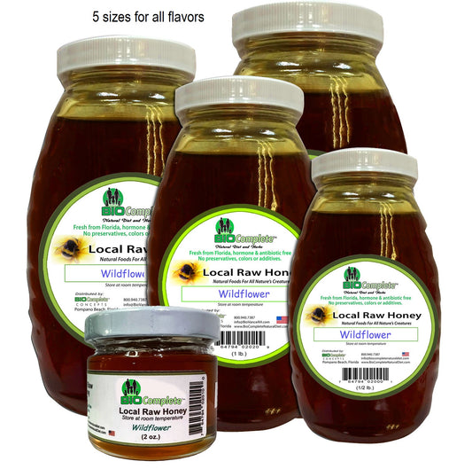Multiple glass jars of BioComplete Local Raw Honey, with various sizes displayed and labels indicating the flavor as 'Wildflower'.