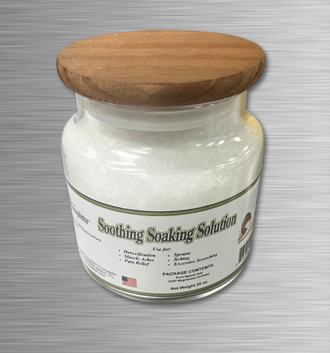 A clear glass jar with a wooden lid, labeled as 'Soothing Soaking Solution' containing white epsom salt.