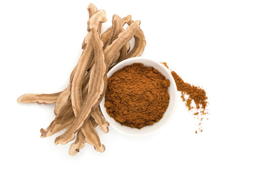 A bowl of BioComplete Reishi Mushroom Powder with slices of reishi mushrooms displayed next to it on a white background.