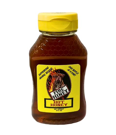 A bottle of Fire Hiney Hot Raw Honey with a yellow cap and a label featuring a bee and the product name.
