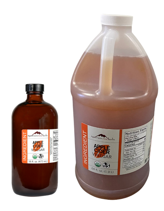 Two bottles of Mountain Rose Herbs Apple Cider Vinegar, one small bottle and one large gallon-size jug, both with labels.