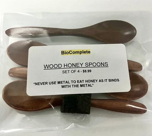 Packaged set of four wooden honey spoons with the brand label 'BioComplete' visible on the packaging.