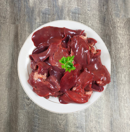 A plate of raw beef liver chunks garnished with a small piece of parsley.
