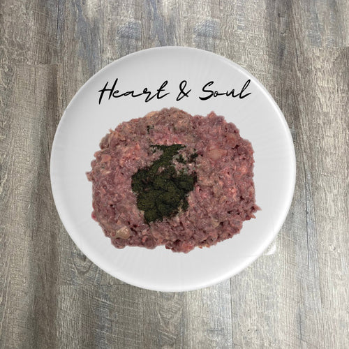 A plate of ground duck meat with visible pieces of organic herbs, labeled 'Heart & Soul'.