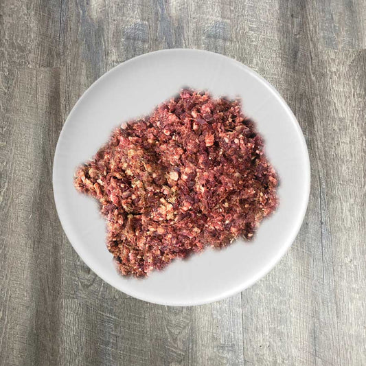 A bowl of ground lamb, heart, and liver mixture, presumably the product mentioned, placed on a plate.