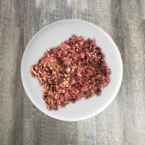 A bowl of ground lamb, heart, and liver mixture, presumably the product mentioned, placed on a plate.