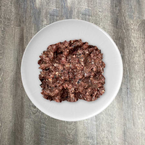 A bowl of BioComplete Natural Raw Mackerel Ground Purity, which appears to be ground mackerel flesh.
